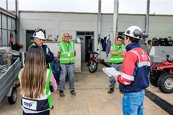 LÍDER SATISFECHO en SST: Un profesional de seguridad en un sitio industrial de Lima revisando una matriz impresa donde se listan las señales de Obligación requeridas, confirmando el cumplimiento del listado oficial NTP.